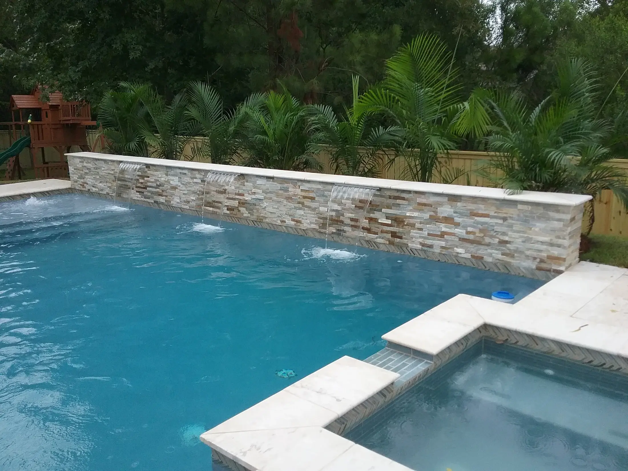 Clearwater custom pool with an accent wall and water features