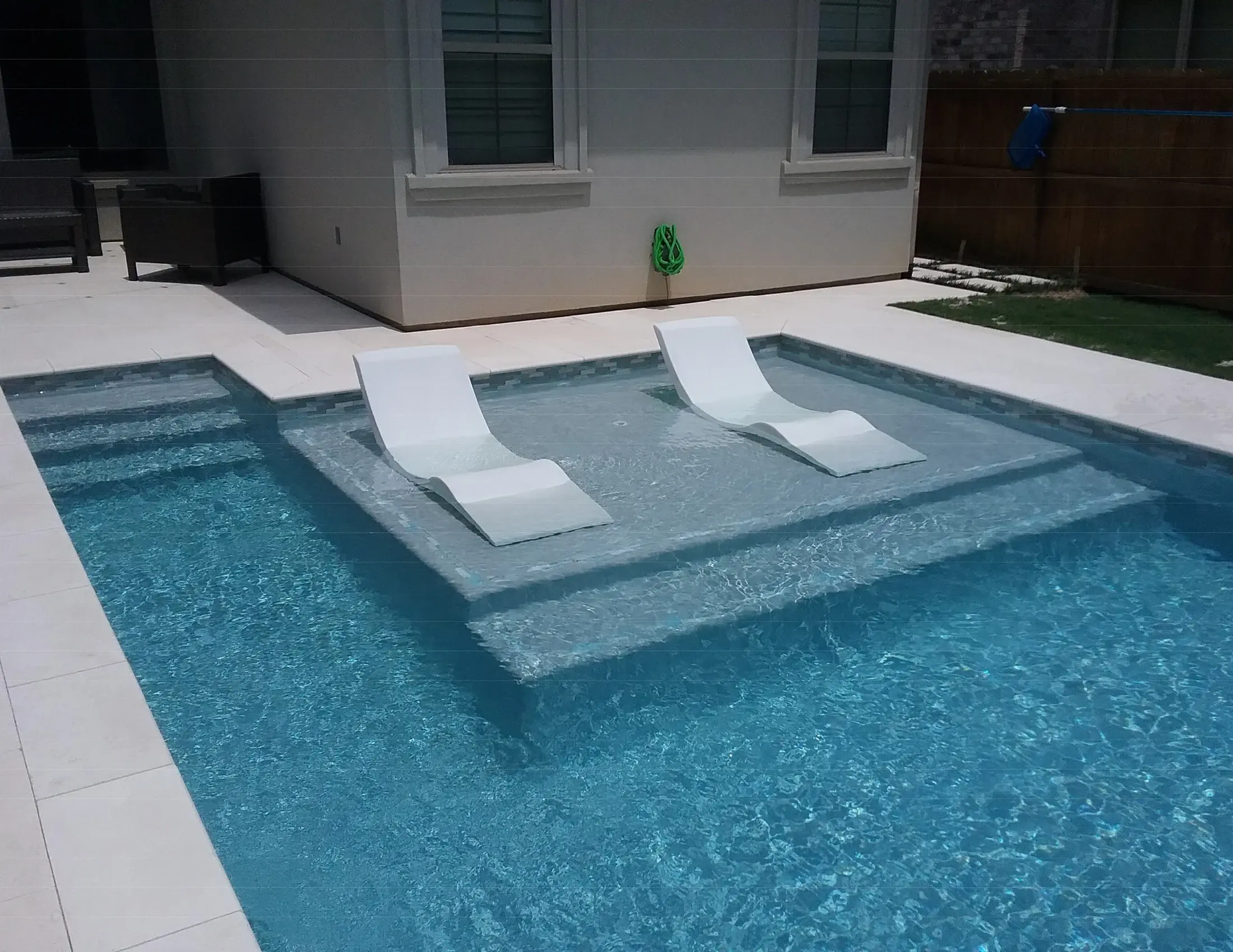 Clearwater pool with a tanning ledge and in-water lounging area