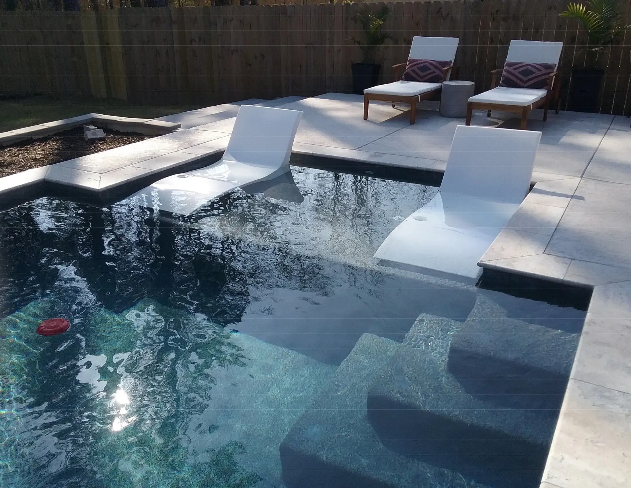 Clearwater pool with a tanning ledge and in-water lounging area