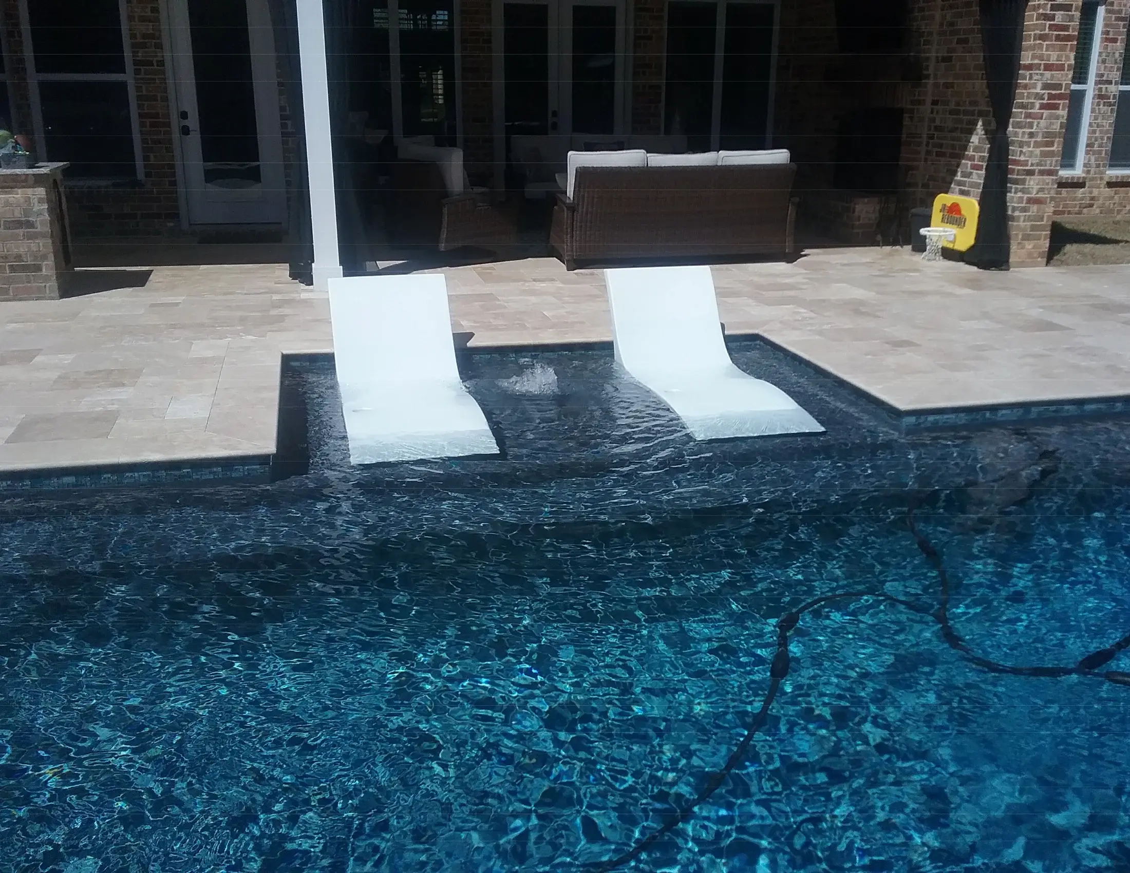 Clearwater pool with a tanning ledge and in-water lounging area