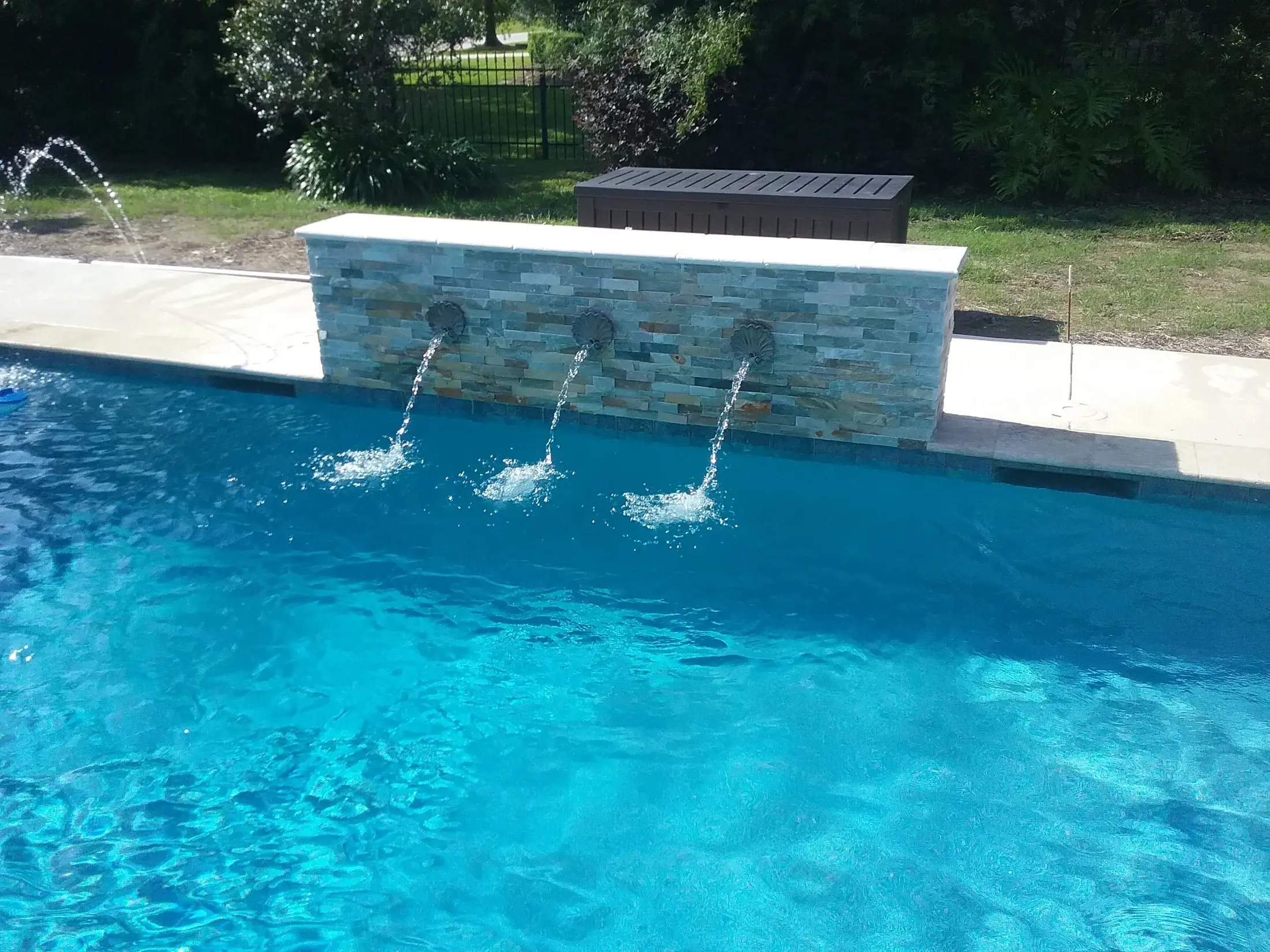 Clearwater custom pool with an accent wall and water features