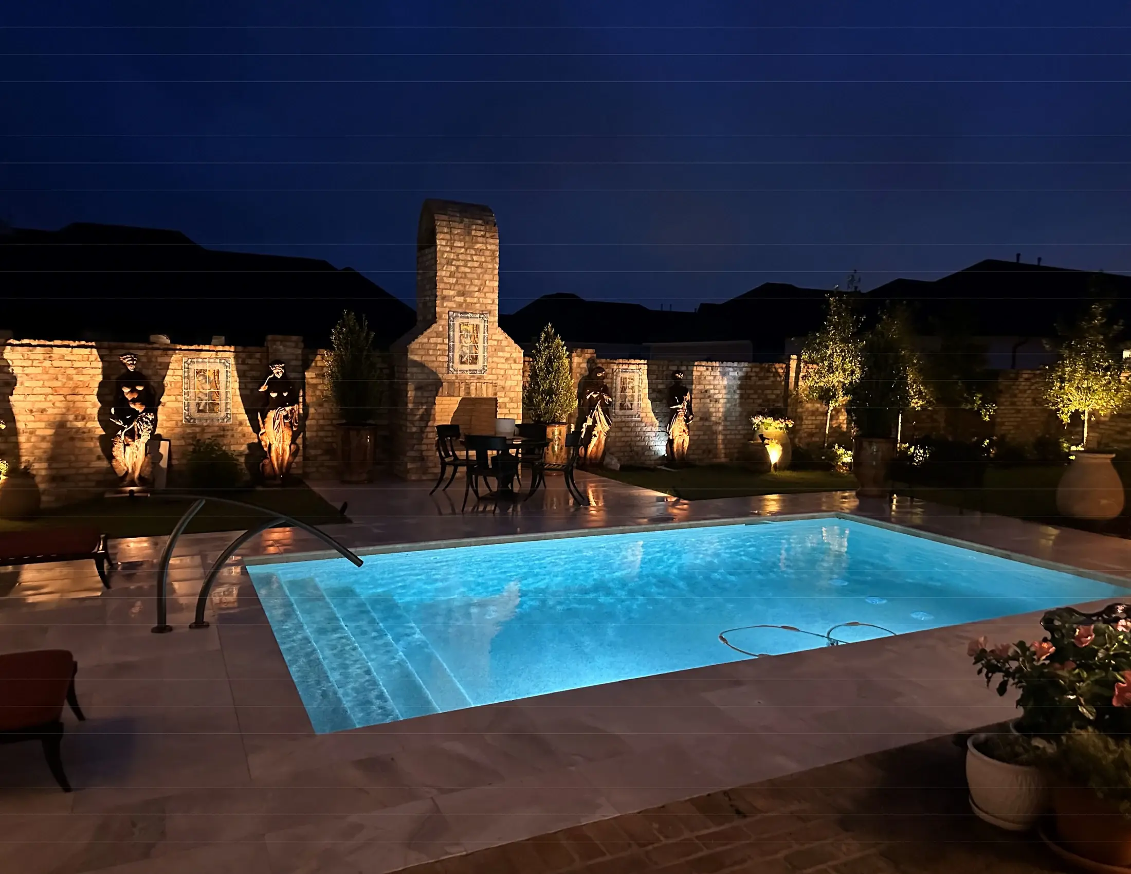 Clearwater custom pool illuminated at dusk with architectural water and fire features